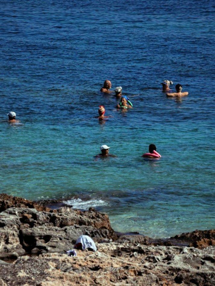Купание в прозрачном море у скалистого берега Мальты
