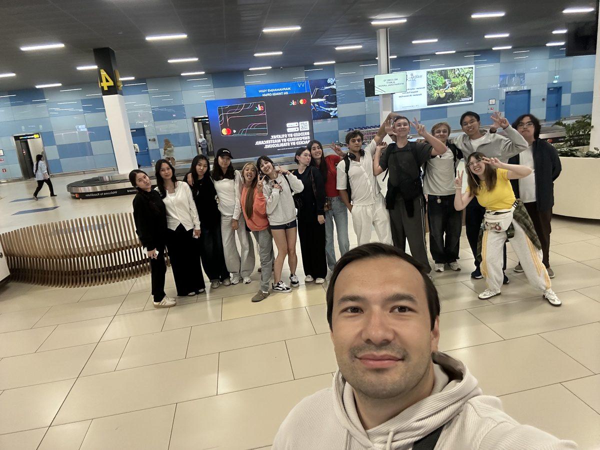 Жанат, директор FLEX Education, встречает группу подростков в аэропорту Алматы